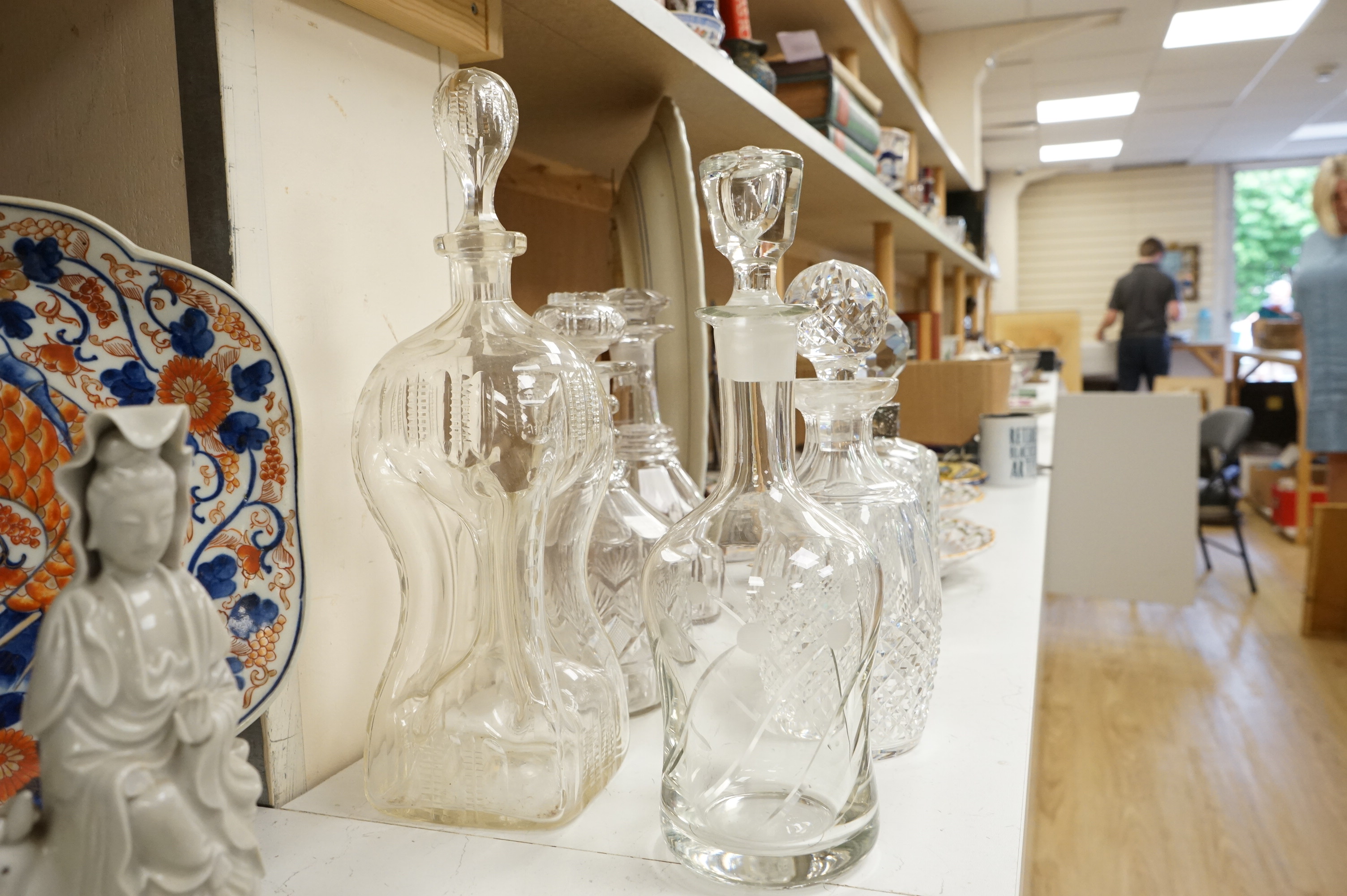 Six 19th century and later cut glass decanters and stoppers, one with white metal acorn design collar, largest 37cm high